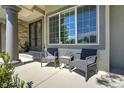 Inviting front porch featuring comfortable seating, decorative columns, and stylish doors at 24031 E Hinsdale Pl, Aurora, CO 80016