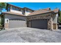Spacious three car garage featuring attractive neutral doors and stone exterior accents at 24031 E Hinsdale Pl, Aurora, CO 80016