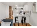 Kitchen with white cabinets, granite countertops, stainless steel appliances and a bar area with pendant lighting at 4780 Pennsylvania St, Denver, CO 80216