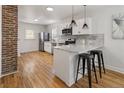Well-lit kitchen featuring stainless steel appliances, granite countertops, and white cabinetry with wood floors at 4780 Pennsylvania St, Denver, CO 80216