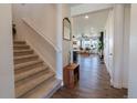 Bright foyer with staircase and hardwood floors, offering a glimpse into the living spaces at 4918 Preserve Pl, Firestone, CO 80504