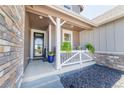 Inviting front porch with decorative railings and potted plants offering a warm welcome at 4918 Preserve Pl, Firestone, CO 80504