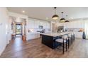 Spacious kitchen featuring a large island with seating, white cabinets, and modern appliances at 4918 Preserve Pl, Firestone, CO 80504