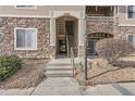 Condo building entrance with stairs and stonework at 8465 S Holland Way # 205, Littleton, CO 80128