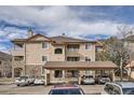 Tan two-story condo building with balconies and carport at 8465 S Holland Way # 205, Littleton, CO 80128