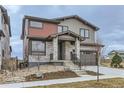 Charming two-story home with a modern gray exterior and stone accents, concrete stairs and minimal yard at 5575 Moosehead Cir, Longmont, CO 80503