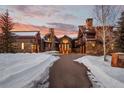 Stunning exterior of a luxurious home with a stone and wood facade at sunset at 220 Cottonwood Cir, Breckenridge, CO 80424