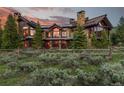 Gorgeous home with a wood and stone exterior and an attractive rustic wooden fence and landscaping at 220 Cottonwood Cir, Breckenridge, CO 80424