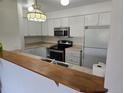 Kitchen featuring white cabinets, stainless steel appliances, and breakfast bar at 14500 E 2Nd Ave # 209A, Aurora, CO 80011