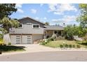 Well-maintained home with a gray exterior, a two-car garage, and a landscaped front yard at 9383 W Colorado Ave, Lakewood, CO 80232