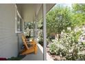 Cozy covered porch featuring two yellow Adirondack chairs and a view of the lush garden at 9383 W Colorado Ave, Lakewood, CO 80232