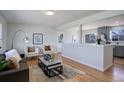 Open concept living space flowing into the kitchen, featuring modern decor and hardwood flooring at 230 W 78Th Pl, Denver, CO 80221