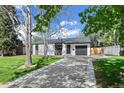Charming single-story home with a well-maintained front yard and a private driveway to a one car garage at 1360 S Forest Way, Denver, CO 80222