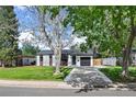 Charming single-story home with a well-maintained front yard and a private driveway to a one car garage at 1360 S Forest Way, Denver, CO 80222