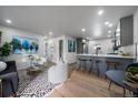 Open-concept living space with an eat in kitchen, featuring stylish furniture, modern art, and wood flooring at 1360 S Forest Way, Denver, CO 80222