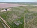 An aerial view showing the home's placement on the expansive green acreage at 62101 E 32Nd Ct, Strasburg, CO 80136