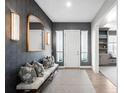 Stylish entryway featuring patterned wallpaper, sconces, bench seating, and hardwood floors at 6938 E Lake Dr, Centennial, CO 80111