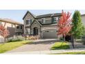 Handsome two-story home with stone details, manicured lawn, and paved driveway at 6938 E Lake Dr, Centennial, CO 80111