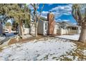 Townhouse side yard with snowy landscaping and brick chimney at 13739 E Marina Dr # B, Aurora, CO 80014