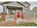 Welcoming front porch with brick pillars, white railings, and a vibrant red front door, enhancing curb appeal at 1488 N Stratton Ave, Castle Rock, CO 80104