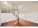 Bright living room featuring gleaming hardwood floors, a staircase, and neutral paint, offering a blank canvas at 1488 N Stratton Ave, Castle Rock, CO 80104