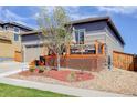 View of the home's exterior highlighting the wooden deck and stone accents leading to the two car garage at 18027 Telford Ave, Parker, CO 80134