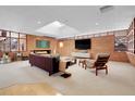 Spacious living room featuring a brick fireplace and large windows at 5030 Aspen Dr, Littleton, CO 80123