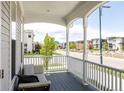 Inviting covered front porch with comfortable seating and views of the neighborhood street at 10106 E 59Th Pl, Denver, CO 80238