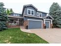 Two-story home with gray siding, three-car garage, and manicured lawn at 3100 Rockbridge Dr, Highlands Ranch, CO 80129