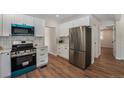 Modern kitchen featuring stainless steel appliances, white cabinets, and a stylish backsplash at 1089 S Osceola St, Denver, CO 80219