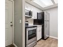 Efficient kitchen features stainless steel appliances, white cabinets, and wood-look flooring at 447 S Memphis Way # 7, Aurora, CO 80017