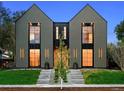 Modern home showcasing a gray exterior, expansive windows with black trim, and a well-kept front yard at 2376 S Bannock St, Denver, CO 80223