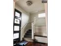 Inviting entryway features wood floors, a staircase with white accents, and a stylish front door at 4428 Perry St, Denver, CO 80212