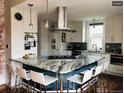 Modern kitchen boasts white cabinets, a marble-top island with seating, and stainless steel appliances at 4428 Perry St, Denver, CO 80212