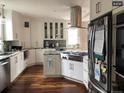 Bright kitchen with white cabinets, stainless appliances, and wood floors, ideal for cooking at 4428 Perry St, Denver, CO 80212