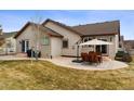 A backyard featuring a stone patio with outdoor seating, a grill, and well-maintained lawn at 4143 Eagle Ridge Way, Castle Rock, CO 80104