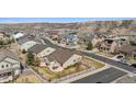 Aerial view of the rear of a house, showcasing a patio area, manicured lawn, and white fencing at 4143 Eagle Ridge Way, Castle Rock, CO 80104