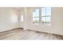 Open-concept living room with large windows and hardwood flooring at 6562 Arbor Blvd # 3, Thornton, CO 80602