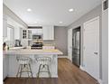 Bright kitchen with stainless steel appliances, white cabinets, breakfast bar, and wood floors offers a modern, functional design at 1343 Valentia St, Denver, CO 80220