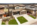Aerial view of a suburban home with a tile roof, manicured lawn, and neighborhood in the background at 14102 Night Owl Ln, Parker, CO 80134