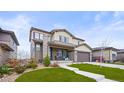 Charming home featuring stone accents, manicured lawn, and covered front porch with seating area at 14102 Night Owl Ln, Parker, CO 80134
