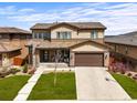 Two-story home showcasing a well-kept lawn, covered front porch, and a two-car garage at 14102 Night Owl Ln, Parker, CO 80134