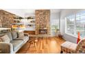 Cozy living room featuring a stone fireplace and built-in shelving at 1995 S Xanadu Way, Aurora, CO 80014