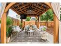 Backyard with a covered patio area, complete with comfortable seating and a TV at 3638 N Elizabeth St, Denver, CO 80205