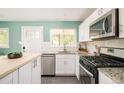 Bright kitchen with stainless steel appliances, granite counters, and white cabinetry at 3638 N Elizabeth St, Denver, CO 80205