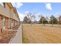 Townhome exterior view with adjacent common green area, showcasing a Gathering-friendly environment at 1188 S Troy St, Aurora, CO 80012