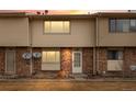 A brick and vinyl exterior of a townhome is captured at sunset, highlighting the unit number above the front door at 1188 S Troy St, Aurora, CO 80012