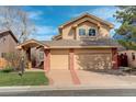 Two-story home featuring a brick and tan siding exterior with an attached two-car garage and manicured lawn at 8101 E Dartmouth Ave # 22, Denver, CO 80231
