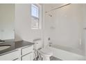 Bathroom with a combined shower and tub, white tiling, and a dark vanity at 7171 Waterleaf Trl, Littleton, CO 80125