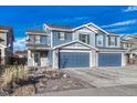 Two-story house with blue siding, stone accents, and a three-car garage at 5780 Raleigh Cir, Castle Rock, CO 80104